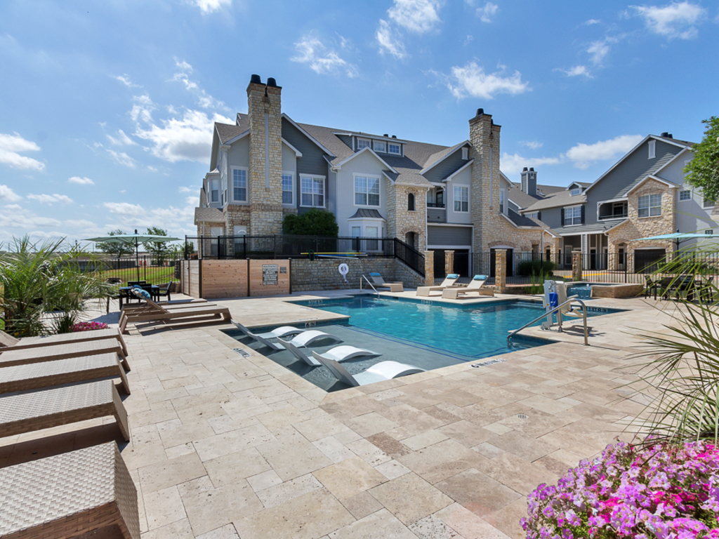 pool with loungers and view of property building